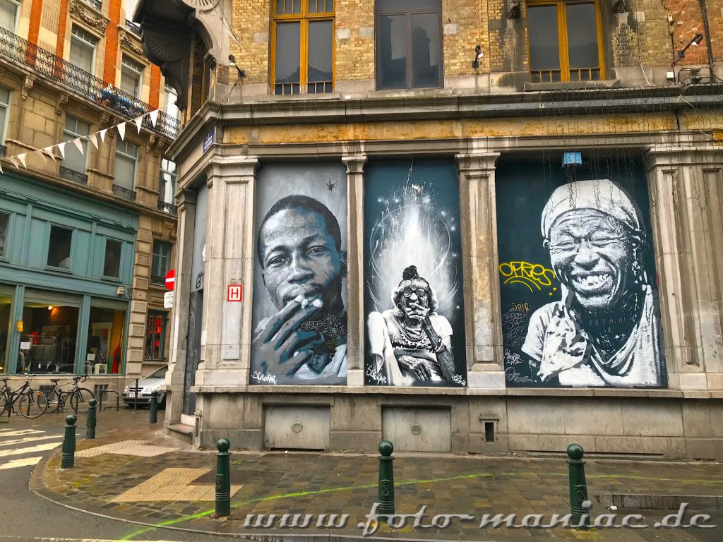 Drei Farbige Porträts auf einer Hauswand in Brüssel