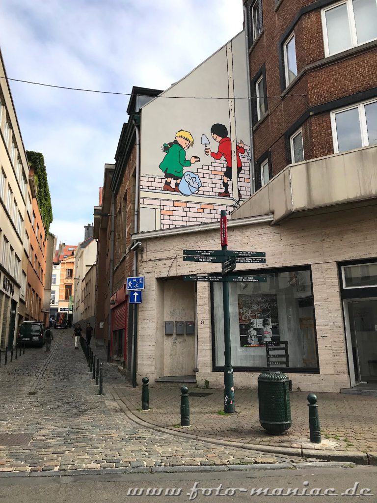 Zwei Comic-Jungs mauern an einer Fassade - Comics gehören zu Brüssels Schokoladenseiten