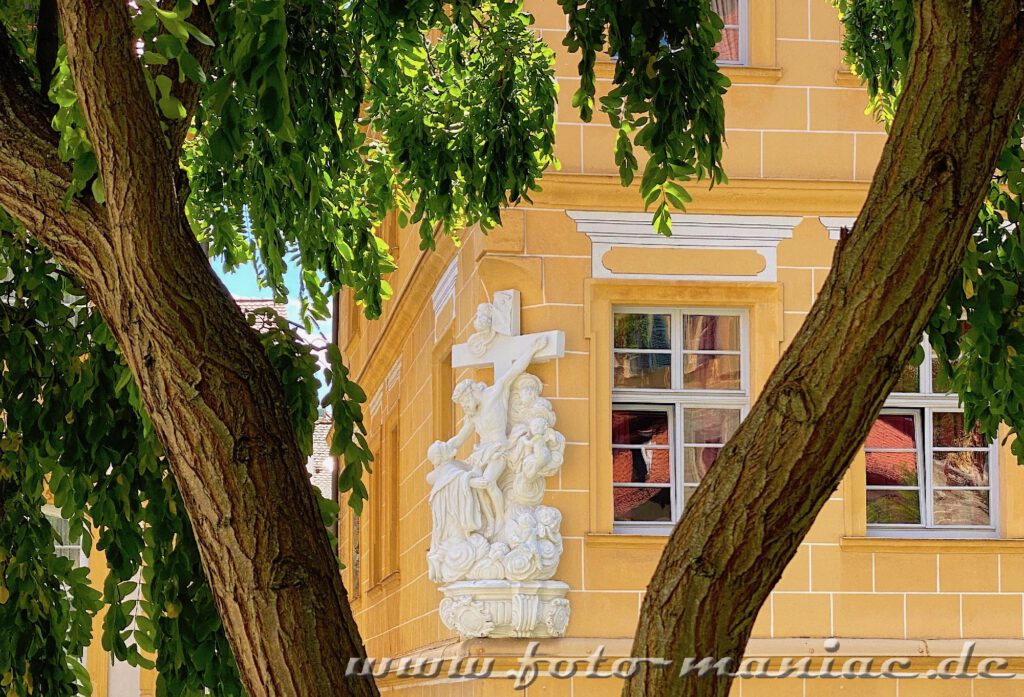 Darstellung von Jesus am Kreuz an einer gelber Fachwerk-Hauswand in Bamberg