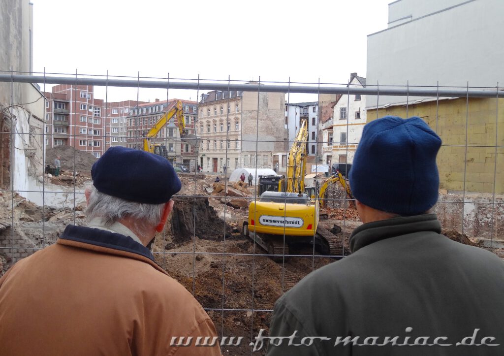 Abriss alter Bauten - zwei Männer beobachten die Bauarbeiten