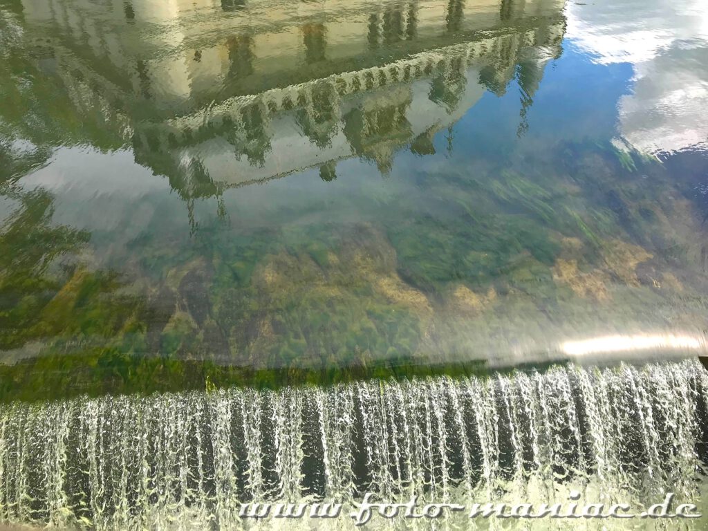 Schloss spiegelt sich am Wasserfall