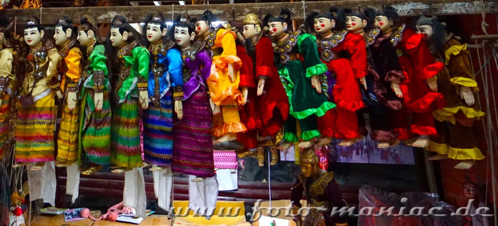 Farbenfrohe Marionetten hängen an einem Verkaufsstand