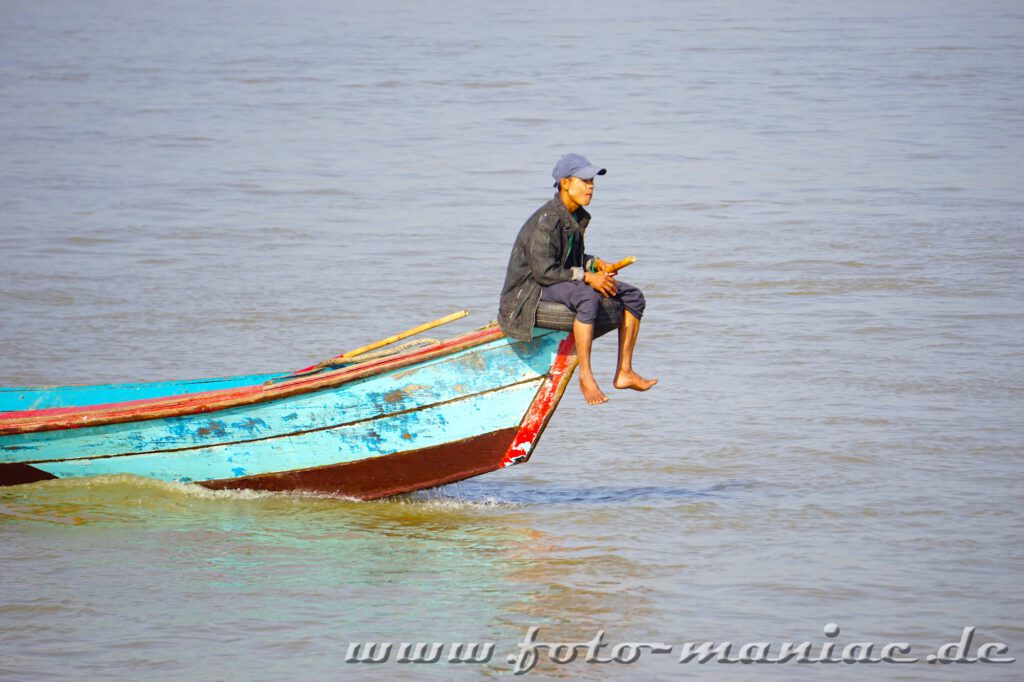 Ein Mann sitzt am Heck eines Fischerbootes