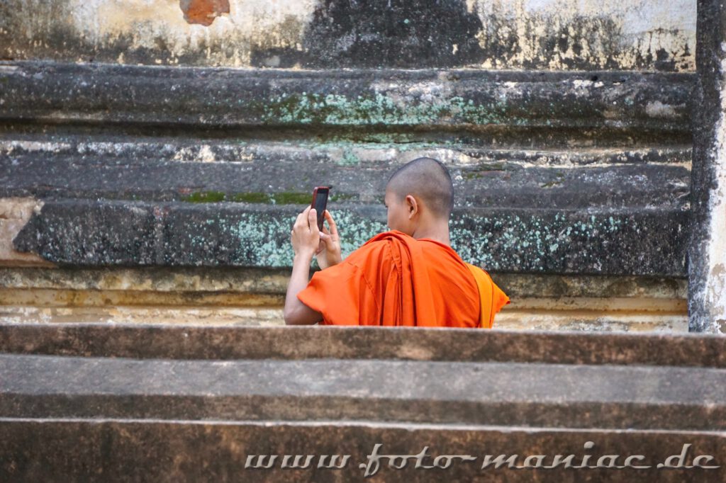Ein Mönch fotografiert mit seinem Handy