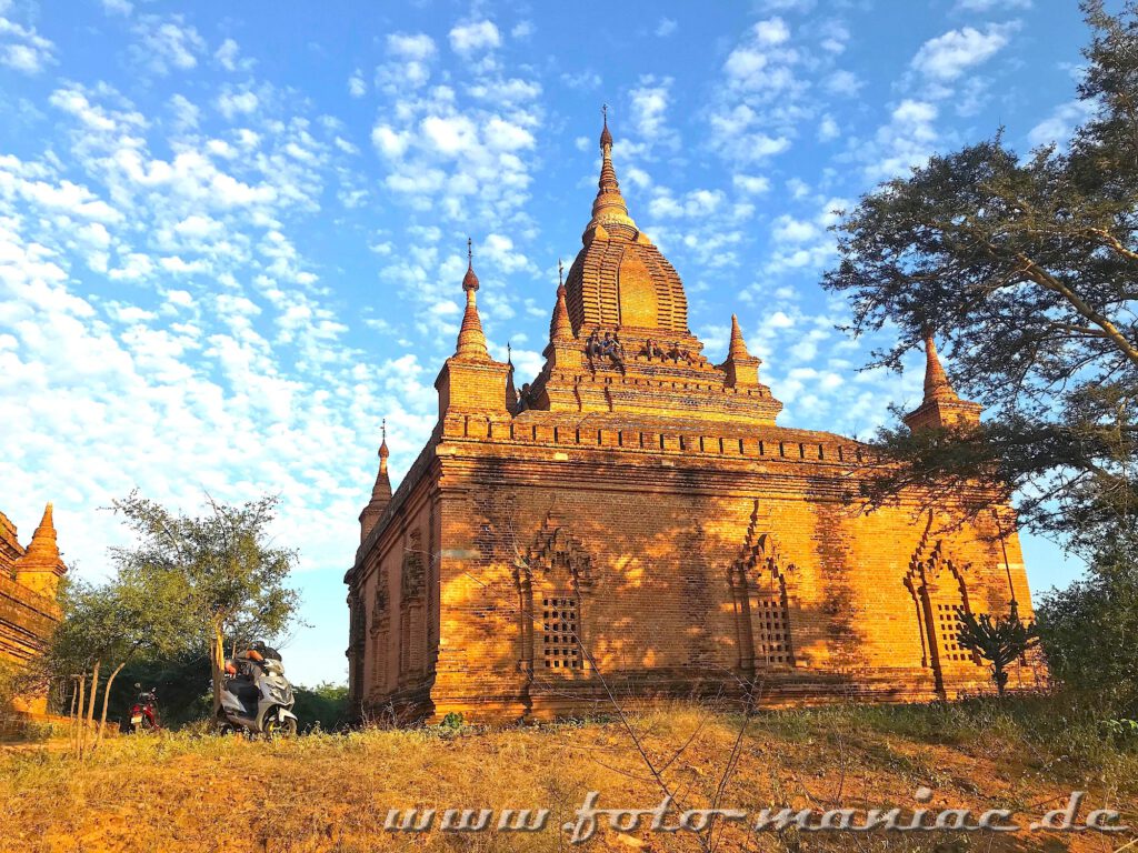 Menschen sitzen in Bagan auf einem Tempeldach