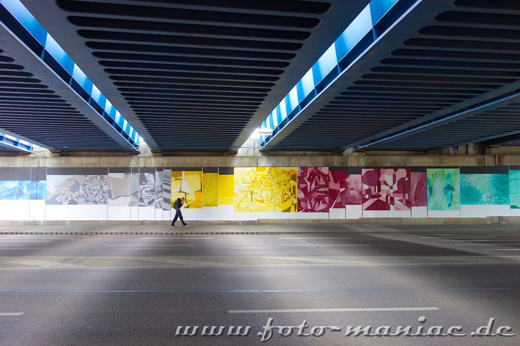 Ein Mann läuft vor einer Graffiti-Wand