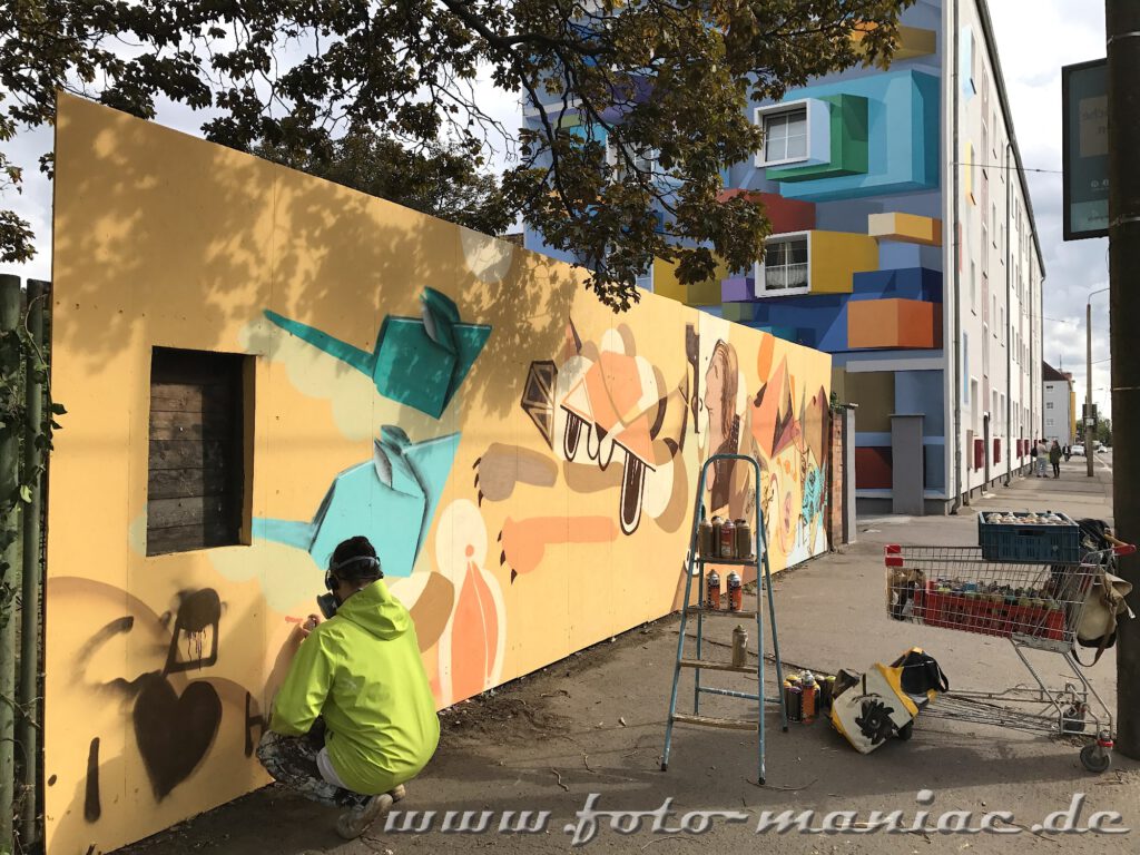 Graffiti-Künstler gestaltet eine Mauer