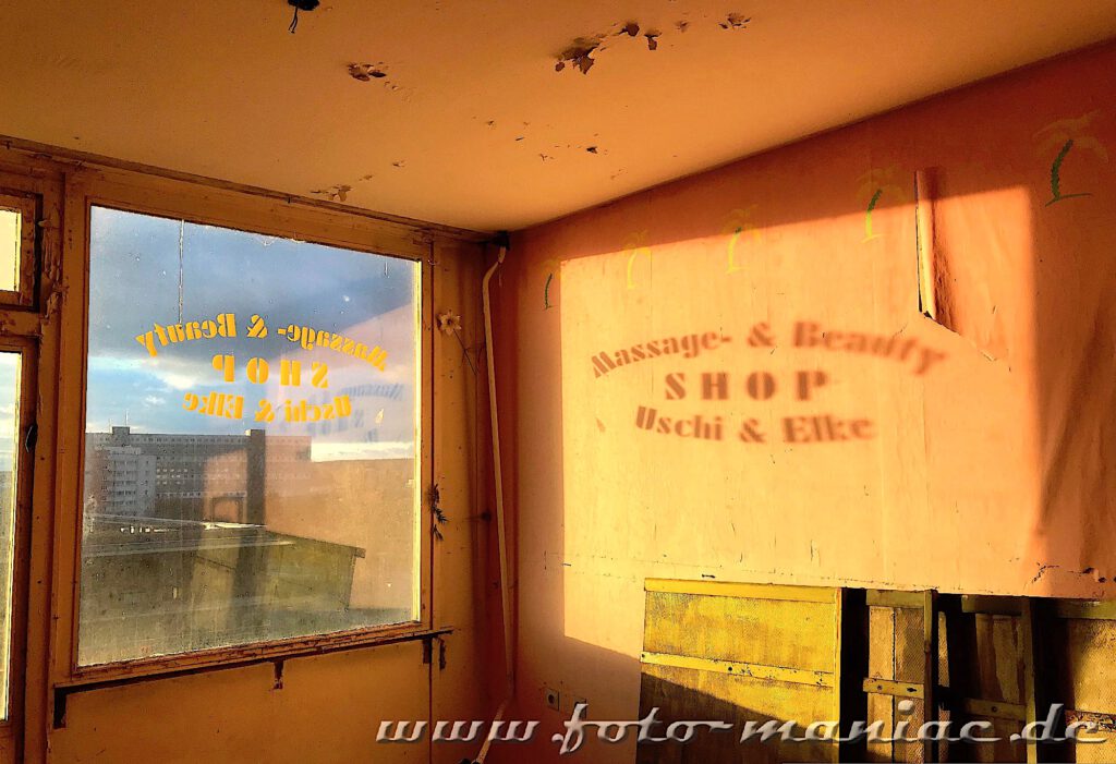 Marode Platte - Spiegelung eines Shop-Namens auf der Wand