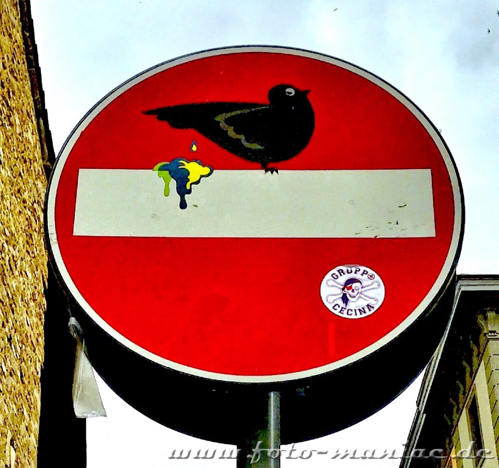 Verkehrsschilder zum Schmunzeln - Vogel kackt auf Balken