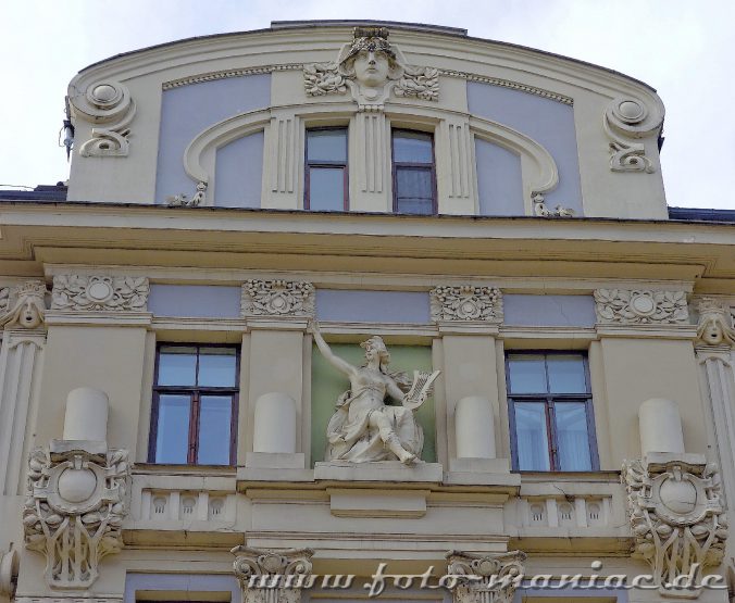 Harfespielende Frau an einer Fassade