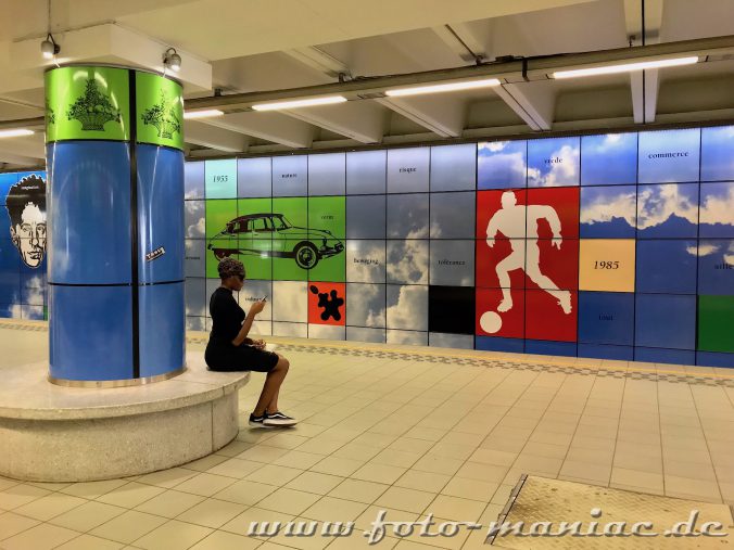 Frau mit Handy in einer U-Bahn-Station in Brüssel