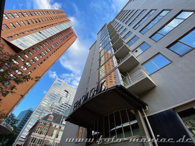 Ein Hochhaus spiegelt sich in der Glasfassade - ein Beisel für Rotterdams Architektur