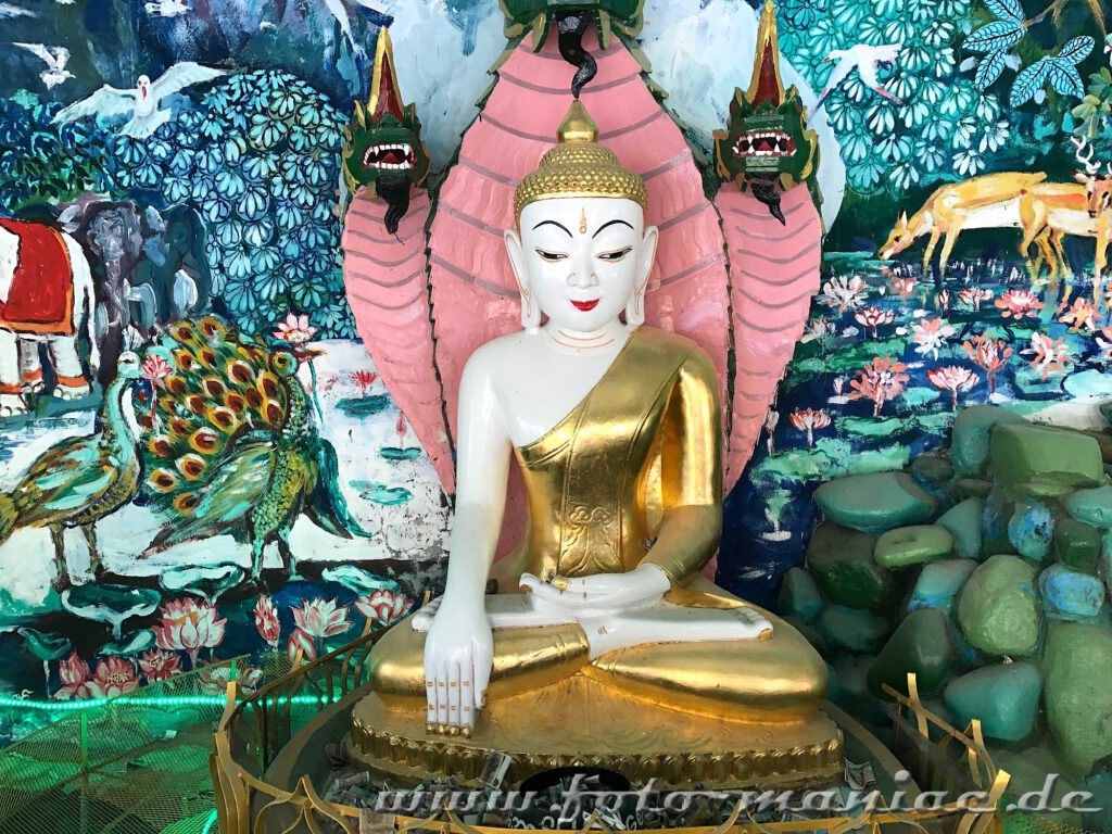 Buddha vor farbenfrohem Gemälde