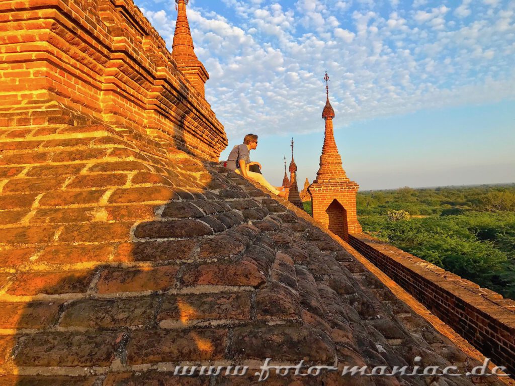 Tempel-hopping in Bagan -Ein Mann sitzt auf einem Tempel 