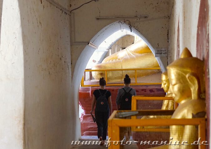 Einzigartige Tempelstadt Bagan - Zwei Touristinnen laufen zu einer großen Buddha-Statue