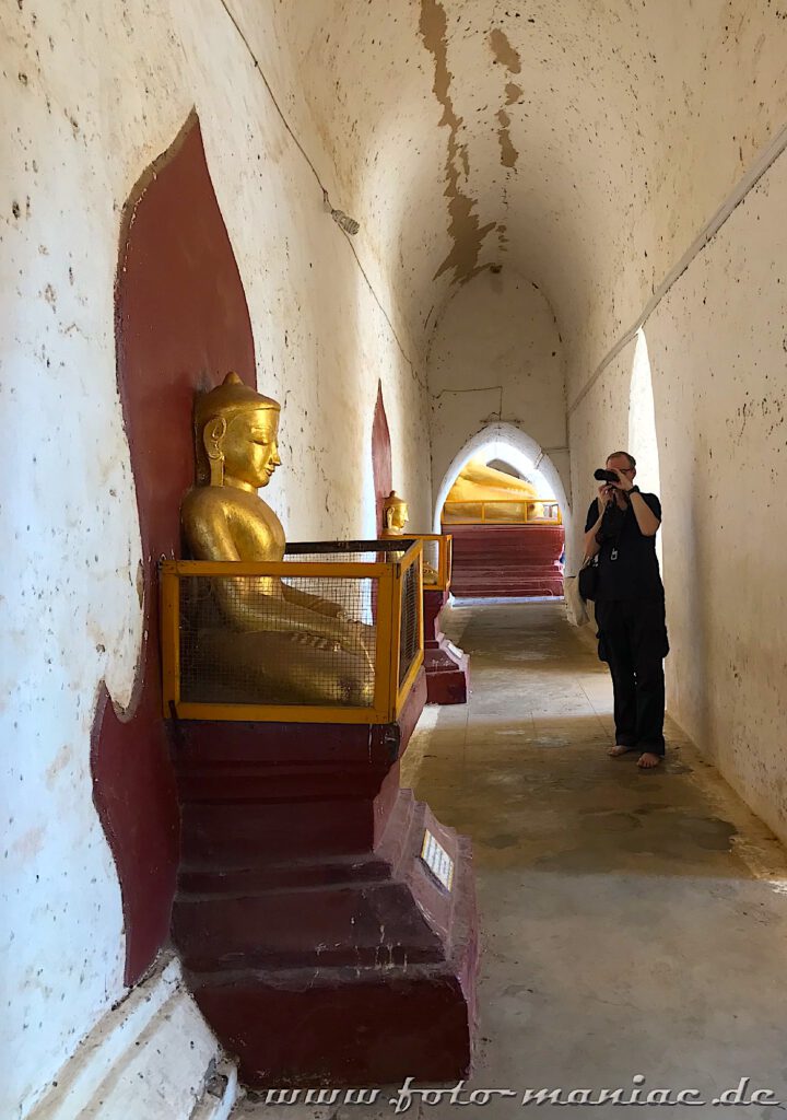 Ein Mann fotografiert in der einzigartigen Tempelstadt Bagan einen Buddha