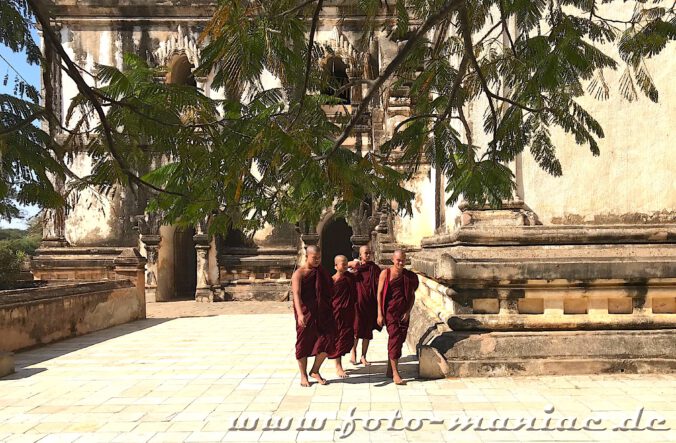 Mönche laufen vor dem Thatbinnyu Tempel in Bagan