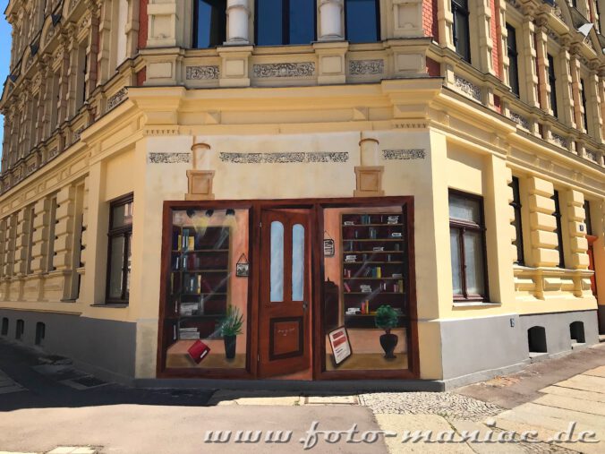 Auf die Ecke eines Hauses einen Eingang zu einem Buchladen gemalt
