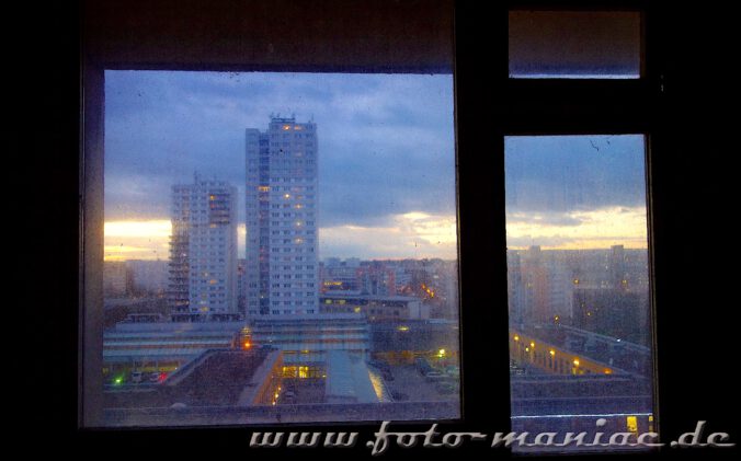 Marode Platte -Blick aus einem Fenster auf die Silhouette von Halle-Neustadt im Dämmerlicht