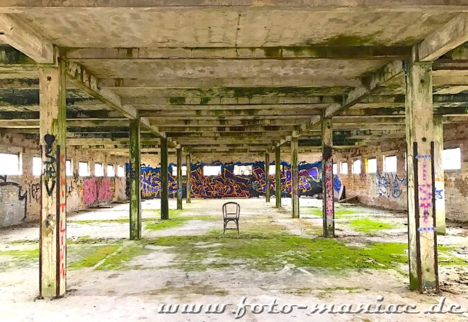 Ein Stuhl zwischen Pfeilern in leerer Halle in der verlassenen Brauerei Sternburg