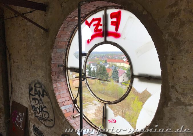 Durch die Reste einer Turmuhr der verlassenen Brauerei Sternburg geht der Blick auf Lützschena