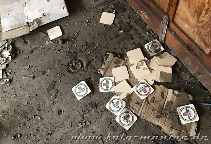 Bierdeckel von der Marke Sternburg liegen auf dem verschmutzten Boden