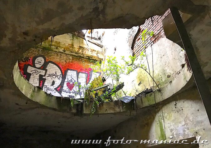 Ein Graffiti-Tag ist durch eine kreisrunde Öffnung zu sehen