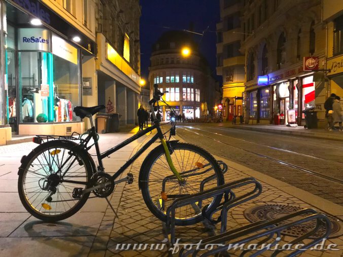 Ein Rad steht in der nächtlichen Innenstadt