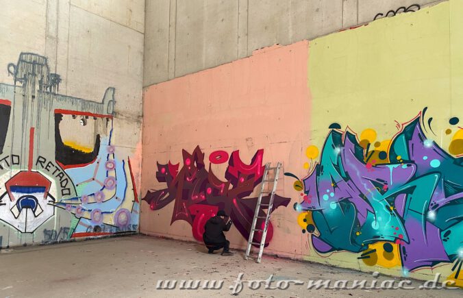 Graffiti-Künstler gestaltet eine Wand