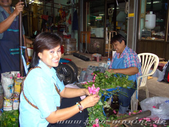 Blumenbinderin auf einem Markt in Bangkok