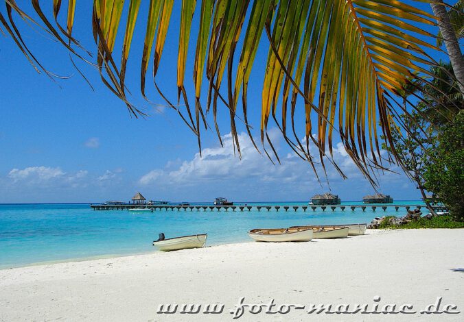 Traumurlaub auf den Malediven - Boote liegen am Strand einer Insel