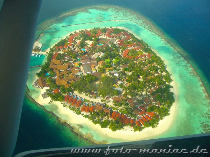 Traumurlaub auf den Malediven - Flugzeug fliegt über einer Ferieninsel