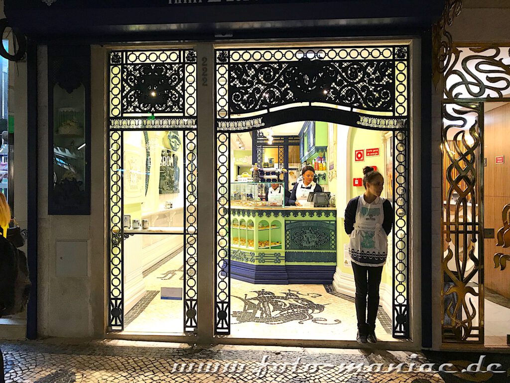 Eine Verkäuferin steht an der Tür eines Geschäfts