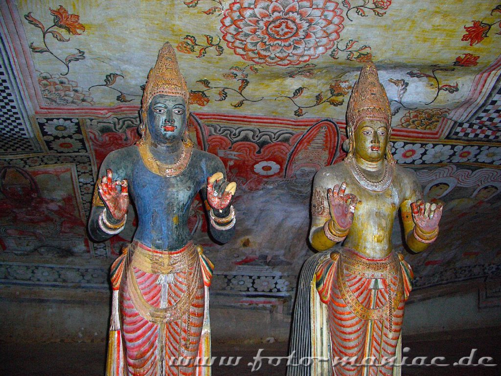 Zwei buddhistische Gestalten stehen im Dambulla-Höhlentempel