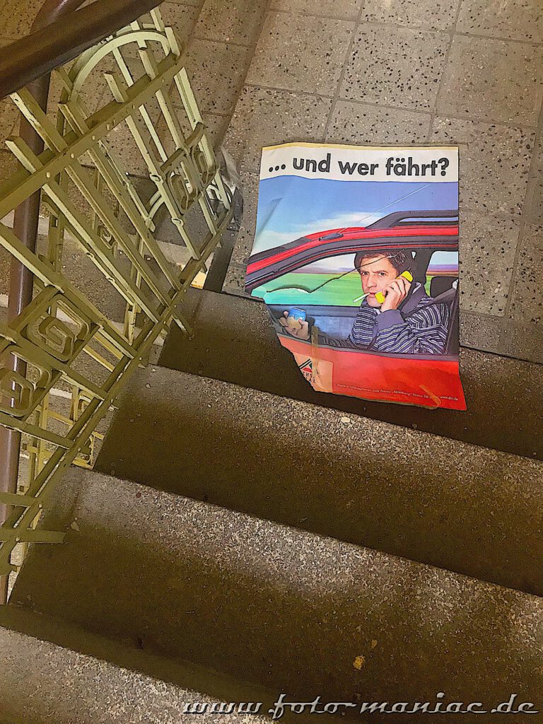 Ein altes Plakat liegt auf der Treppe
