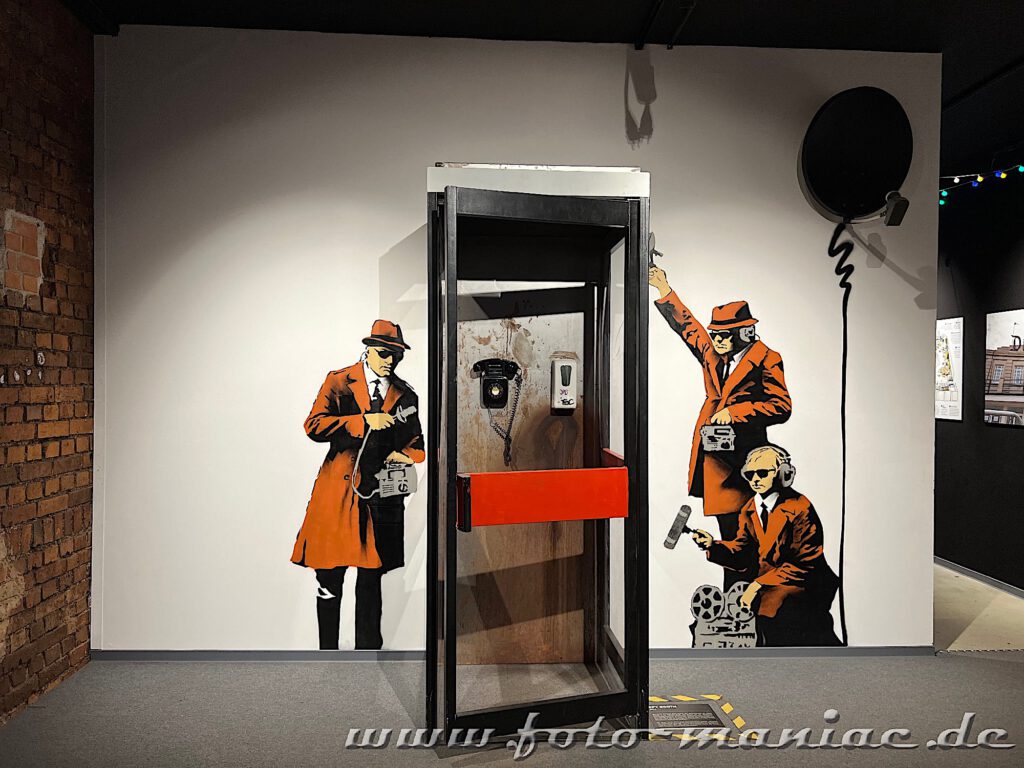 Banksy im Kunstkraftwerk Leipzig - drei Reporter vor einer Telefonzelle