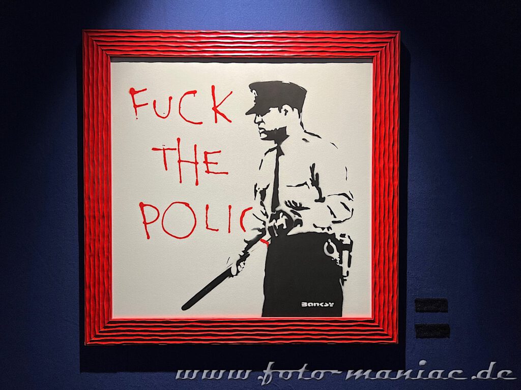 Polizist vor der Graffiti-Botschaft "Fuck the Police"