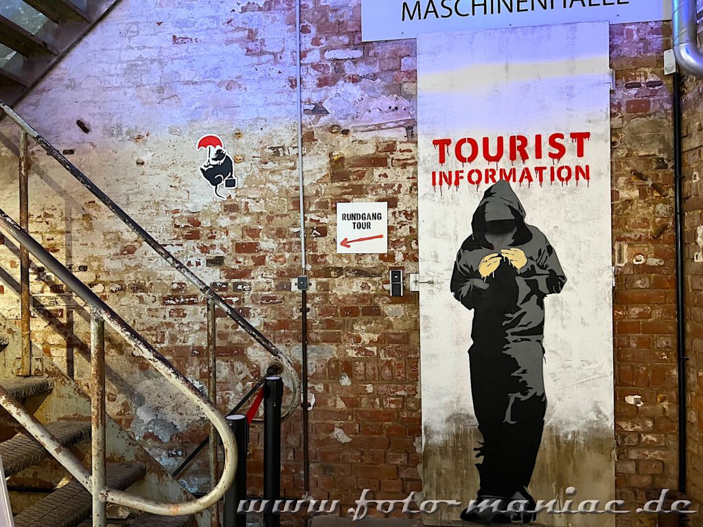 Ein Bild von einem Sprayer mit Kapuze im Kunstkraftwerk Leipzig
