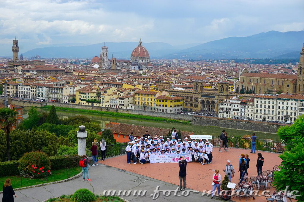 Kurzreise nach Florenz: Eine Reisegruppe lässt sich vor der Kulisse der Stadt fotografieren