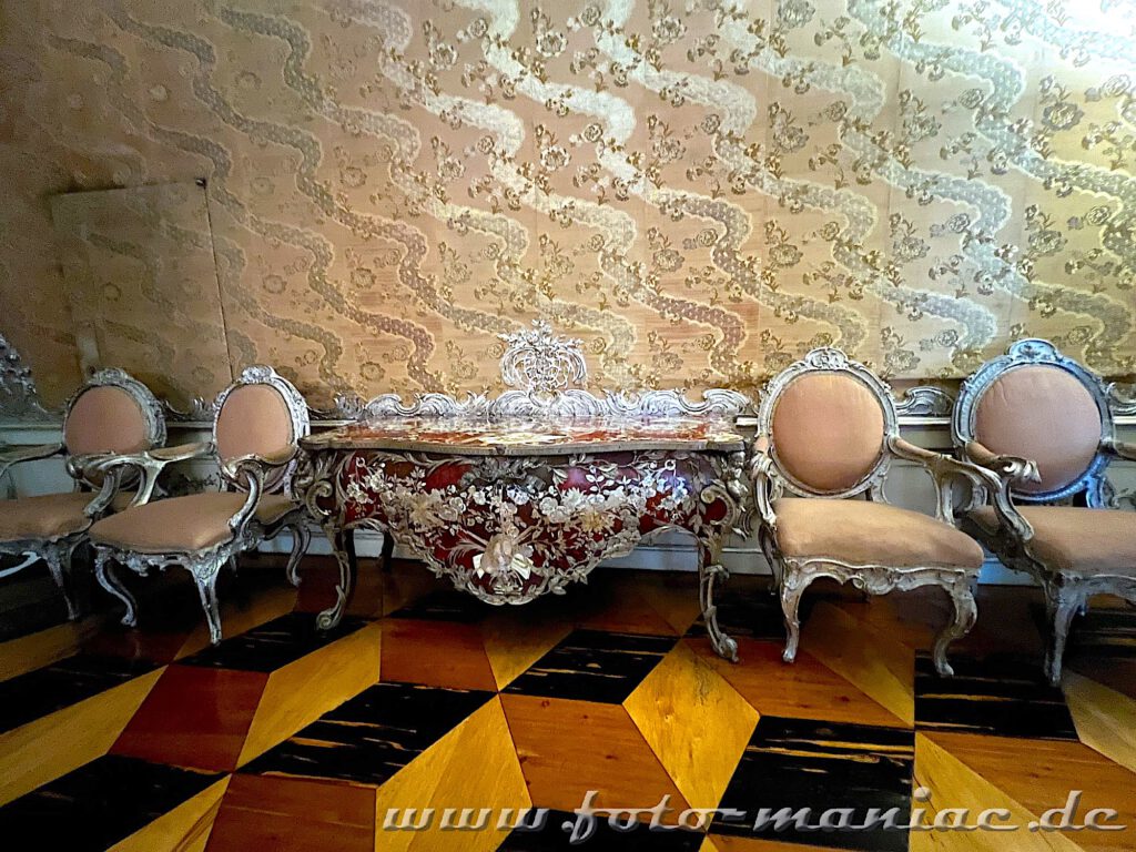 Edle Seidentapete, kostbare Sitzmöbel und ein dekorativer Fußboden in der Königswohnung im Neuen Palais in Potsdam