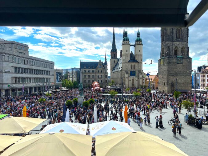 Gulliver in Halle: Blick vom Eiscafé auf die Riesenfigur, die markanten Türme der Saalestadt und das Händeldenkmal