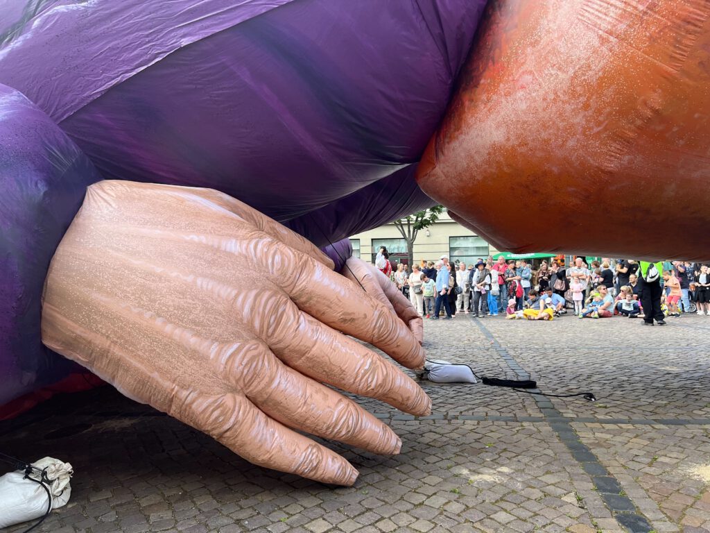 Zuschauer beobachten den liegenden Gulliver in Halle