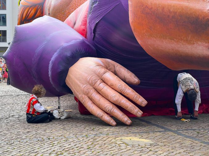 Frau sitzt neben der Riesenhand von Gulliver in Halle