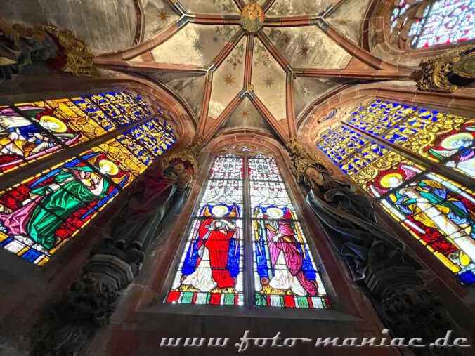 Farbenfrohe Bleiglasfenster sowie Skulpturen in der Taufkapelle der Peterskirche in Straßburg