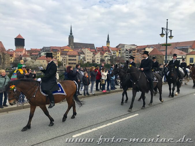 Festlich gekleidet und singend passieren die Osterreiter von Bautzen die Friedensbrücke