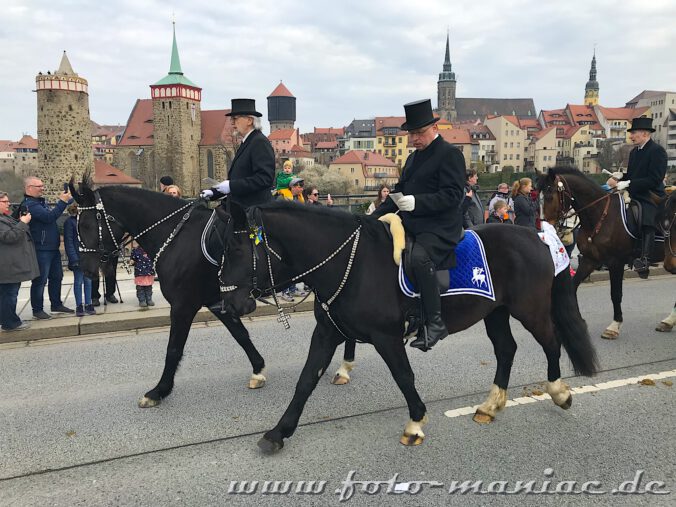 Festlich gekleidet und singend passieren die Osterreiter von Bautzen die Friedensbrücke